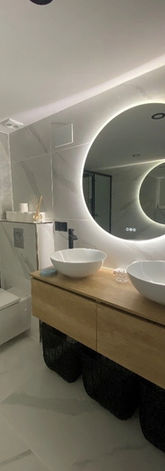 Salle de bain moderne avec carrelage effet marbre et meuble double vasque bois.