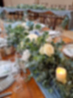 Eye-level view of a rustic wedding table setting with wildflowers and candles