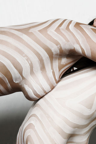 Photograph of two people with close ups of their breasts painted by The Line Girl with abstract white lines