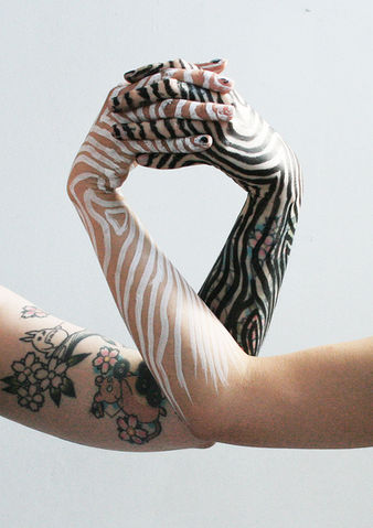 Photography of two hands holding hands both painted by The Line Girl, one is painted in black lines whilst the other is painted in white