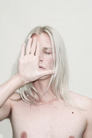 Photograph of man with his face painted by The Line Girl with white abstract lines.