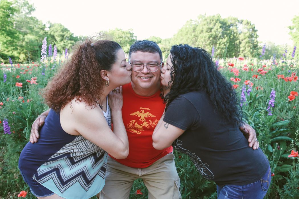 3 siblings posing, with the two sisters kissing their brother on his cheeks during a family photography session with Captured by Shawna in Gallatin, TN