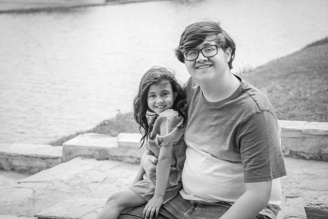 A brother and sister sit together near a river during their family photography session in Gallatin, TN with Captured by Shawna
