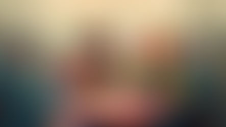 Smiling elderly group gathered at a table with drinks on red-checkered cloth; lively background with more people, warm lighting.