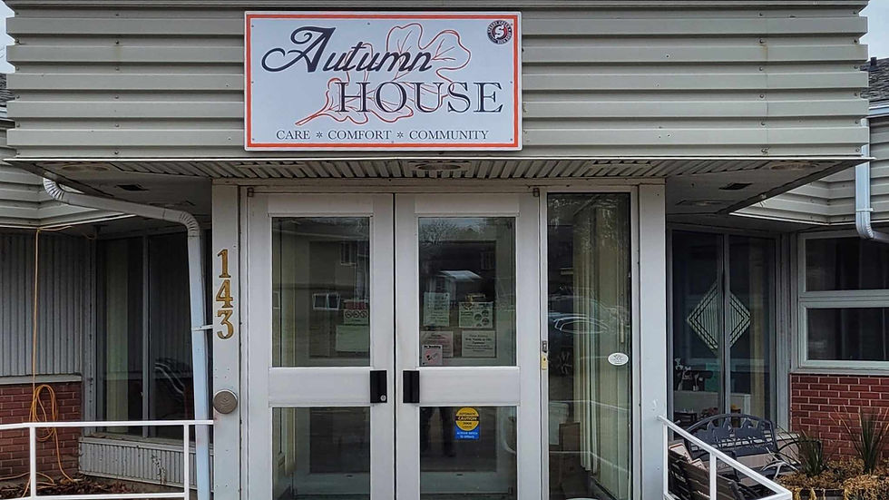 Entrance to Autumn House building with white doors, address 143, and sign reading CARE COMFORT COMMUNITY.