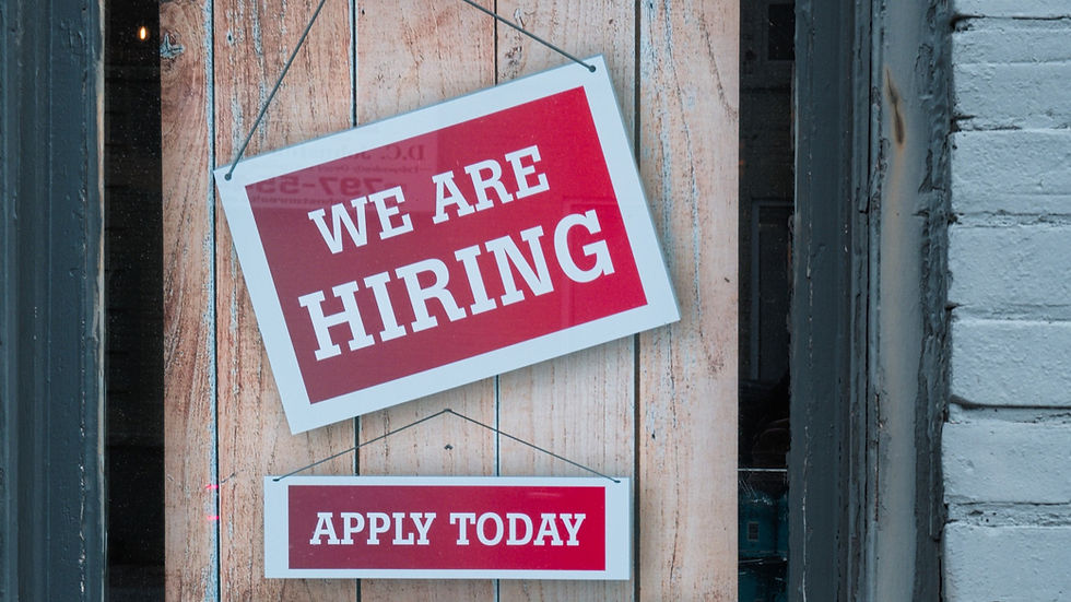 Red signs on wooden background read "WE ARE HIRING" and "APPLY TODAY", conveying urgency and opportunity.