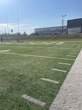 Football fields synthetic turf installation  from sideline.