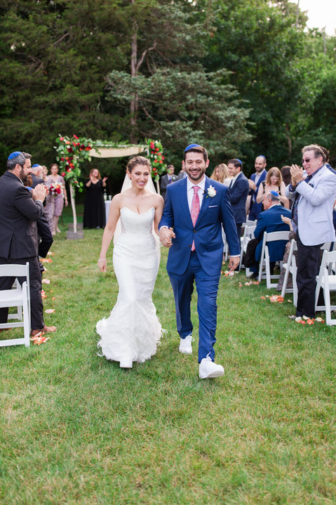 Bride and groom walk down the aisle at an outdoor wedding