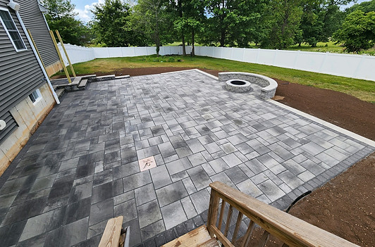 Paver patio with fire pit and seating wall.