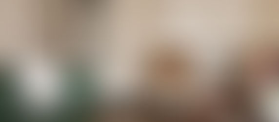 1. Entrance Corridor Brutalist-inspired entrance corridor with sculpted wall figures and polygonal lantern lighting at Eastern Grove Mumbai.  2. Living Room Luxury living room with green tufted sofa, sculptural chairs, black marble accents, and herringbone flooring in Mumbai residence.  3. Dining Area Circular marble dining table with curved-back chairs and fluted panel detailing in Eastern Grove by HS Desiigns.  4. Kitchen Modern kitchen with grey cabinetry, terracotta shutters, and black granite countertops in Mumbai luxury home.  5. Master Bedroom Serene master bedroom with soft neutral tones and sculptural circular wall art in Eastern Grove residence.  6. Crane Panel Bedroom Bedroom featuring hand-carved wooden crane panel and dark fluted partitions in Mumbai residence.  7. Four-Poster Bedroom Classical bedroom with four-poster bed and elegant mouldings in Eastern Grove by HS Desiigns.  