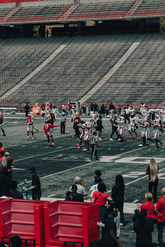 An animated sideline exchange takes place as players and staff gather and react to the conclusion of a play.