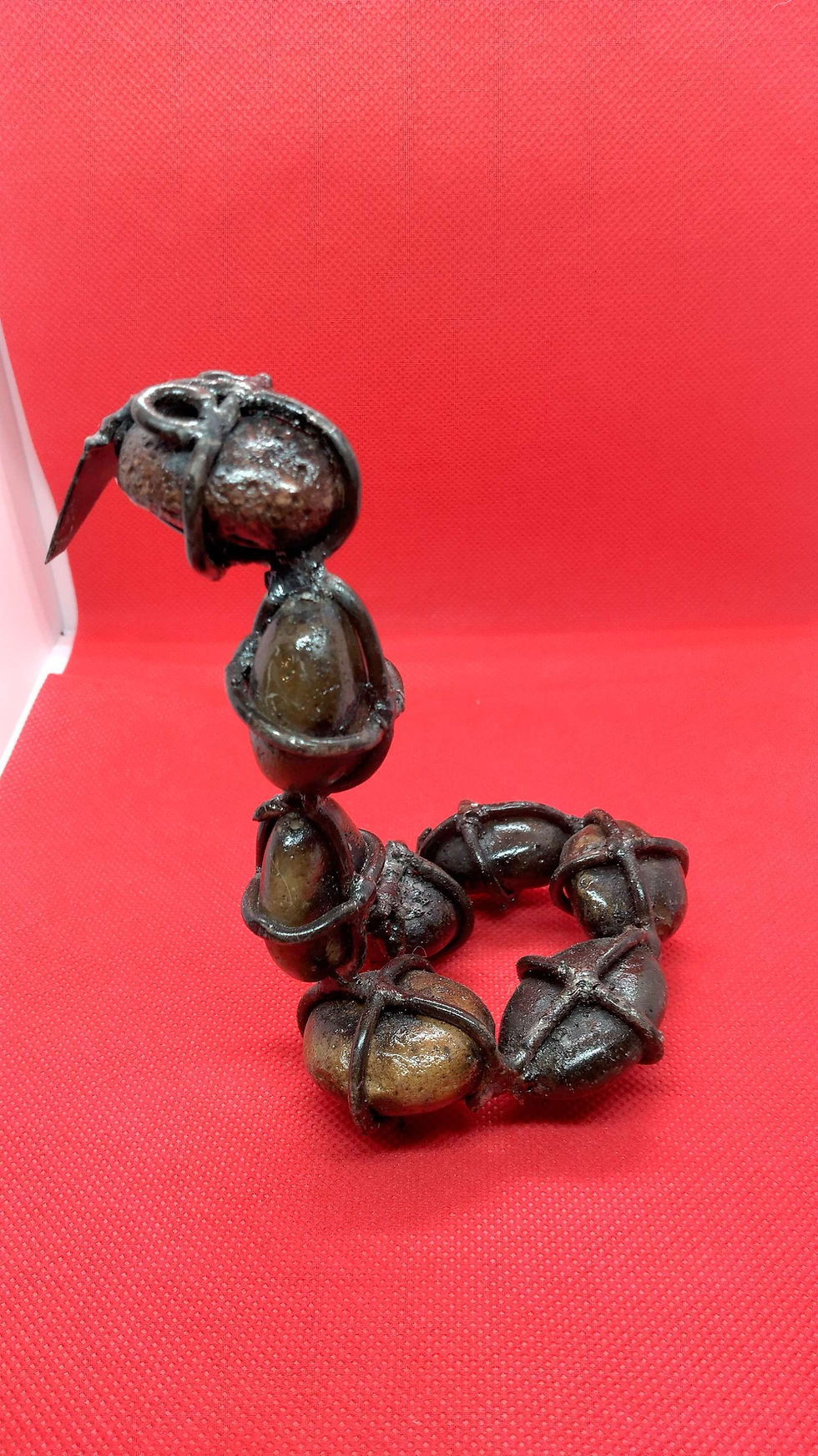 Thumbnail: Metal snake with rocks