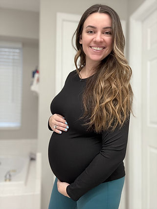 Side profile of woman cradling baby bump