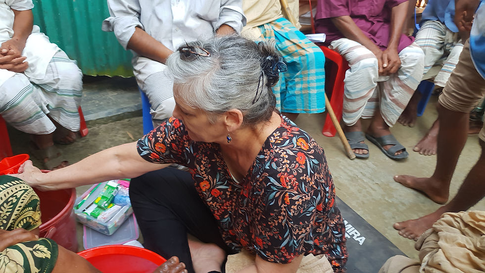 Demonstrating the foot washing routine. You can also see the kit box which contains medicated creams and other items they will need.