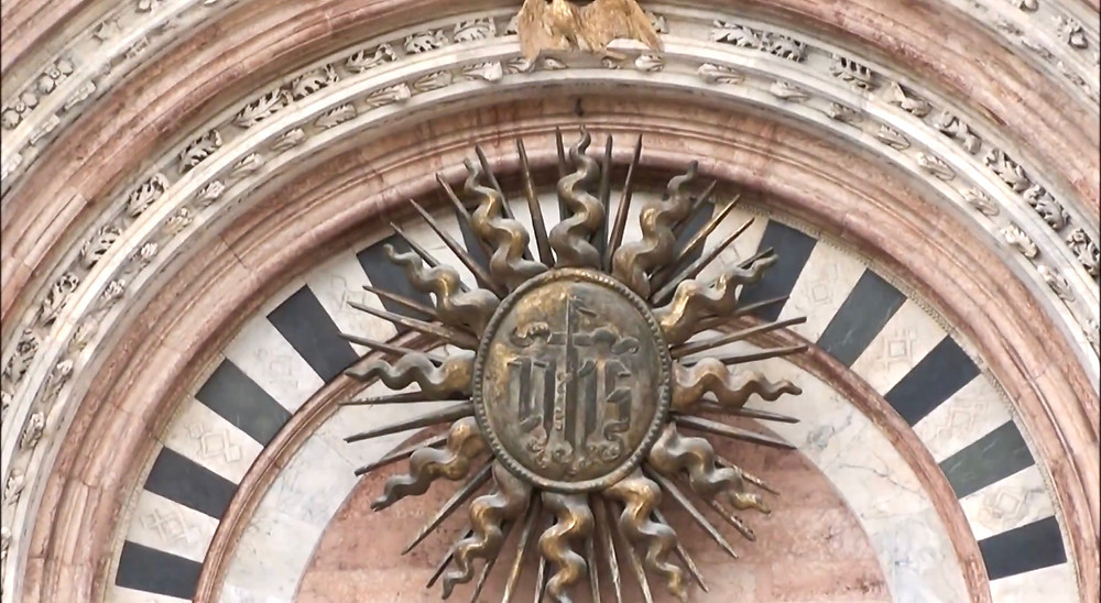 he sunburst in the central portal of the facade of Siena Cathedral