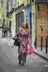 Villanelle goes on a shopping spree following a successful kill in Vienna, dressed in a Burberry Mac coat, Lanvin blouse, and Balenciaga boots.