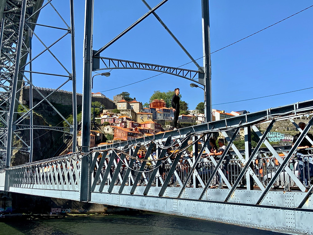 a fearless man about to jump from the Dom Luis I bridge