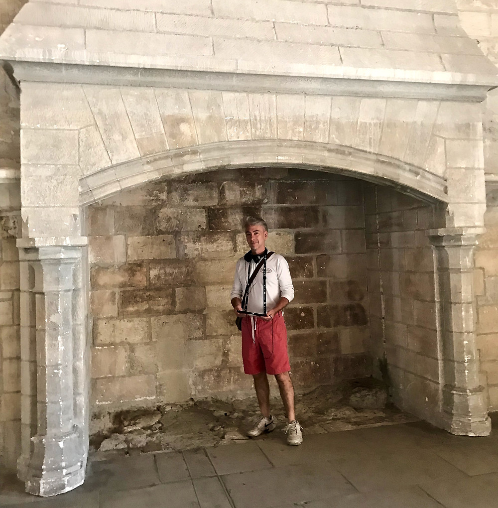 my travel partner standing in a massive stone fireplace with histopad in hand