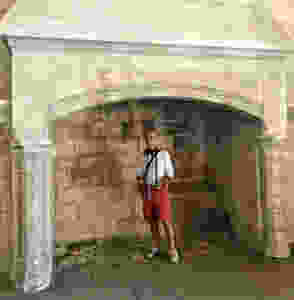 my travel partner standing in a massive stone fireplace with histopad in hand
