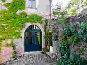 a beautiful stone wall and arched door in Cordes sur Ceil