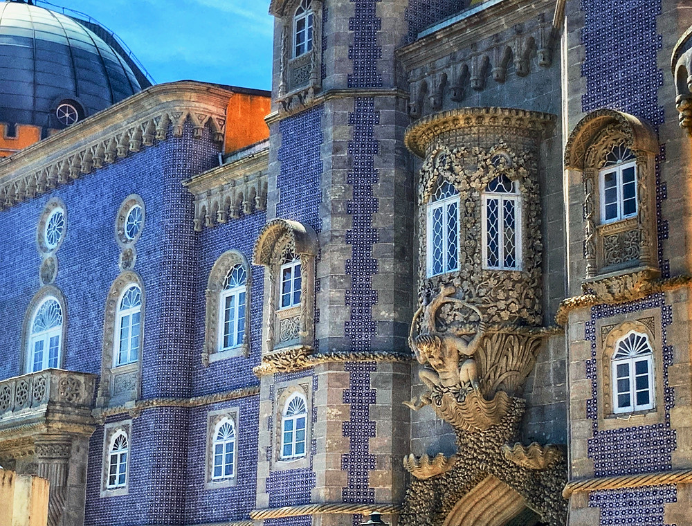 blue tiled facades of Pena Palace and the merman gargoyle over an entryway