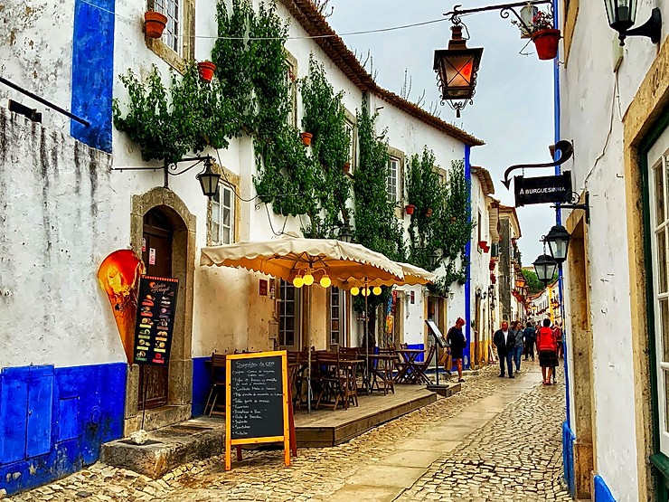 Rue Direita in Obidos Portugal, lined with artisan shops and cute little eateries