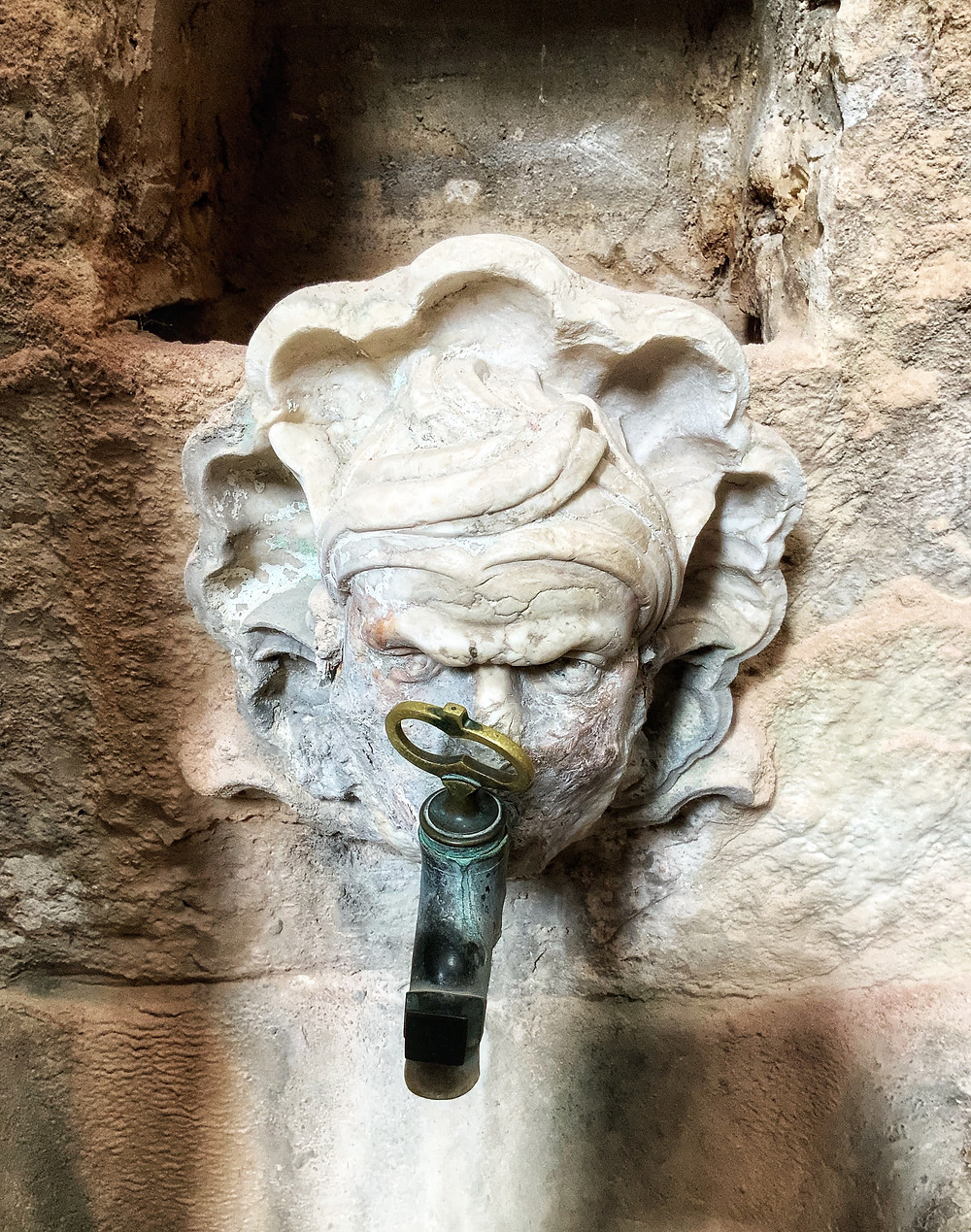 a very angry looking person or gargoyle in a kitchen sink
