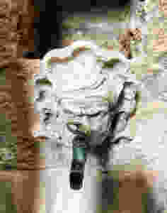 a very angry looking person or gargoyle in a kitchen sink