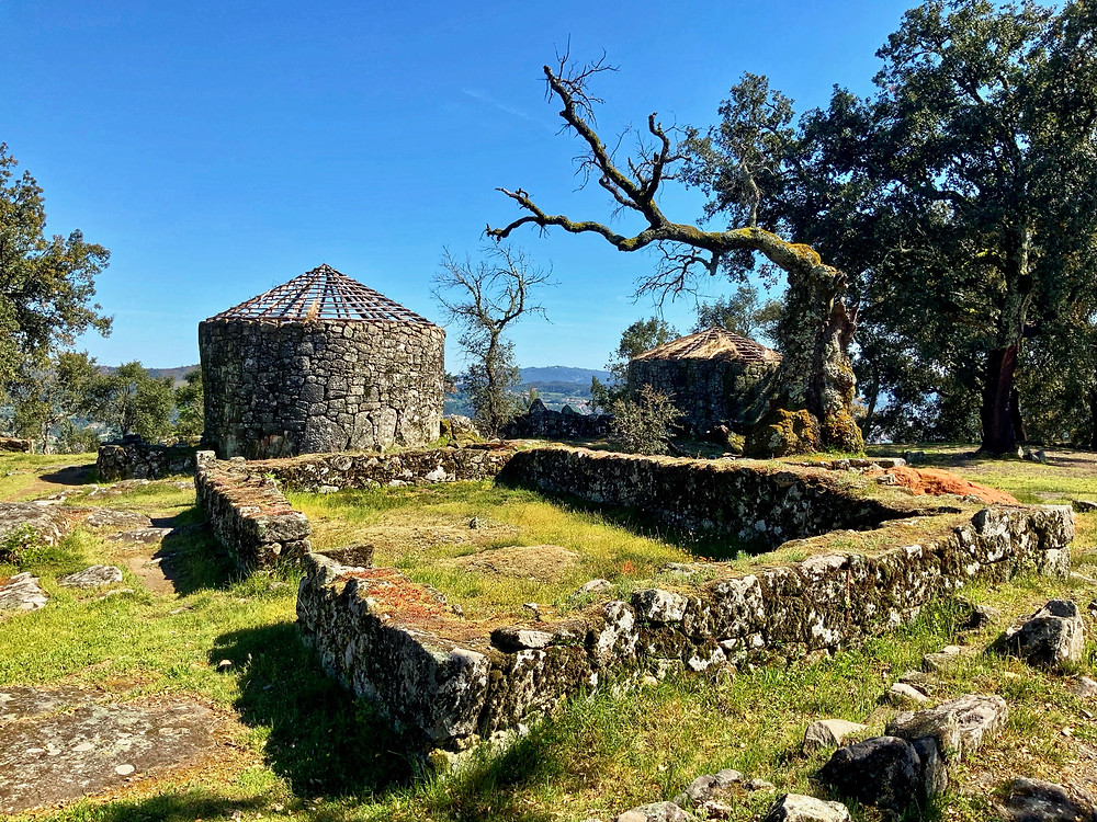 the two reconstructed stone huts on the archaeological site