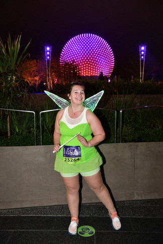 A runner in a Tinkerbell costume in front of Spaceship Earth