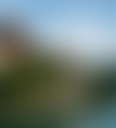 Punakha Dzong, a majestic fortress monastery nestled between two rivers and surrounded by lush green hills in Punakha, Bhutan, under a clear blue sky.