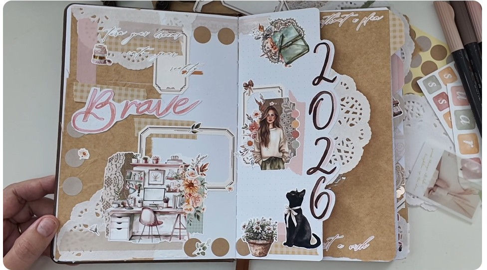 High angle view of a person’s desk with a bullet journal, a cup of tea, and a camera set up for recording a YouTube video