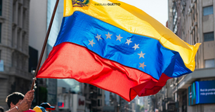 Bandeira da Venezuela sendo agitada por popular