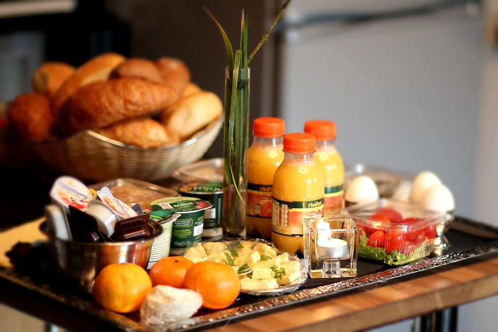 Fruehstuecksbuffet mit Broetchen, Orangensaft, Obst und Aufschnitt