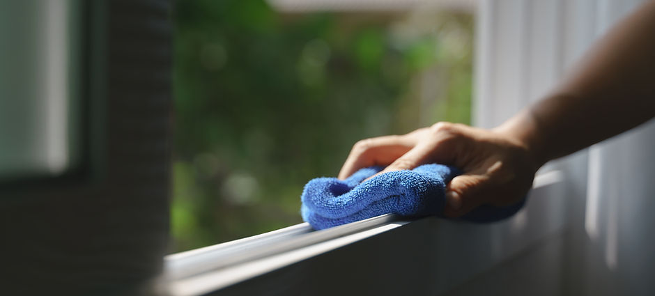 Hand holding blue microfiber cloth for cleaning dust on the glass window rail.jpg