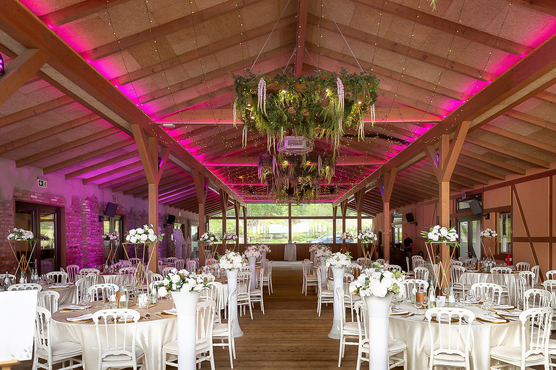 Weitwinkelaufnahme des Innenbereichs des Saals der Hochzeitlocation Lavenda am See in Berlin, bereits komplett für das Abendessen und die Party vorbereitet.