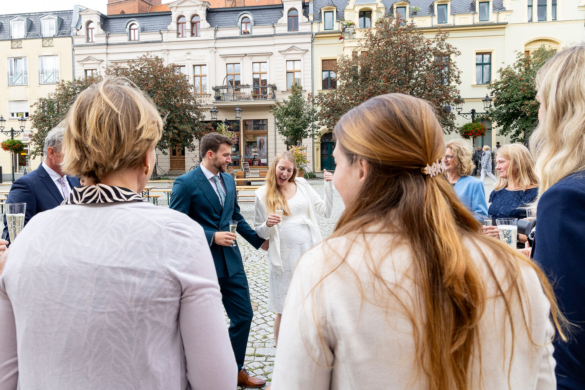 Vor dem Standesamt Bernau führen Brautpaar und Gäste einen Sekempfang (einen traditionellen Tanz) auf. Die Braut ist überglücklich und schneidet lustige Grimassen.
