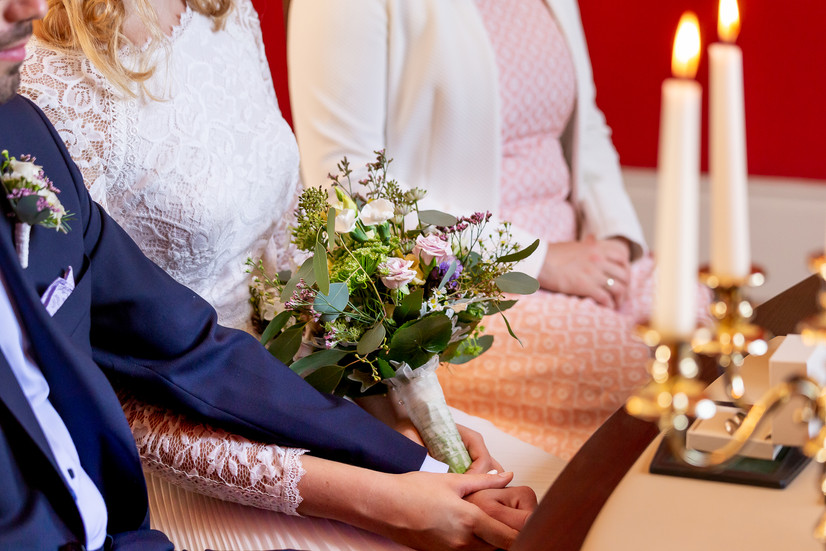 Brautpaar hält sich bei der Hochzeit im Jagdschloss in Schorfheide an den Händen