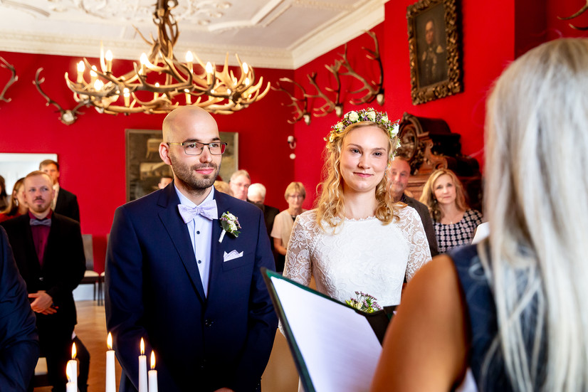 Brautpaar hört sich die Rede während der Hochzeit im Jagdschloss in Schorfheide an