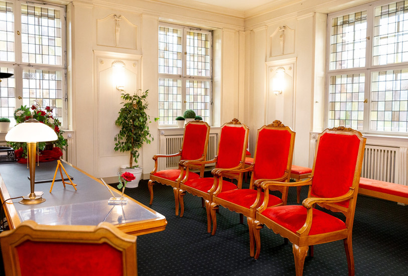 Weitwinkelaufnahme des roten Traumzimmers im Büro in Schöneberg, Berlin, mit dem Schreibtisch. Das Traumzimmer ist gut fotografiert und leer.