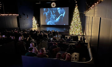 A crowd of people watching a film on the Lyric Theater's giant screen.