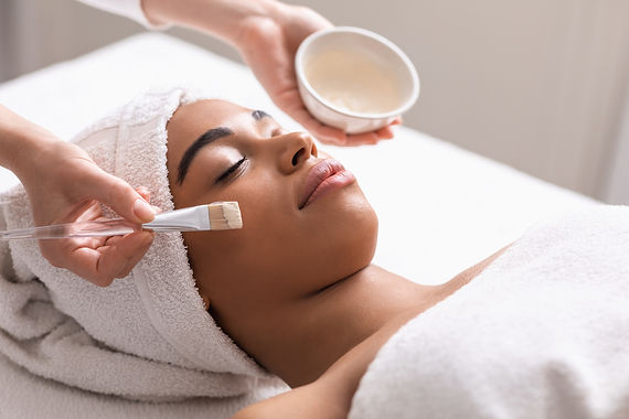 Spa therapist applying face mask on african woman skin, closeup.jpg