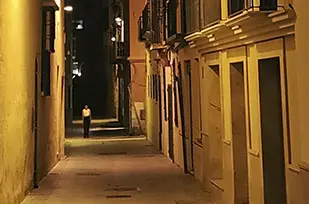 Calle del casco antiguo de Málaga con una misteriosa figura al fondo, por donde pasa la visita guiada nocturna de Málgaturismo.es