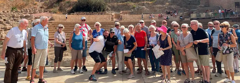 Guía de MálagaTurismo.es durante una visita guiada a Málaga, con un grupo de visitantes Noruegos a los pies del Teatro Romano