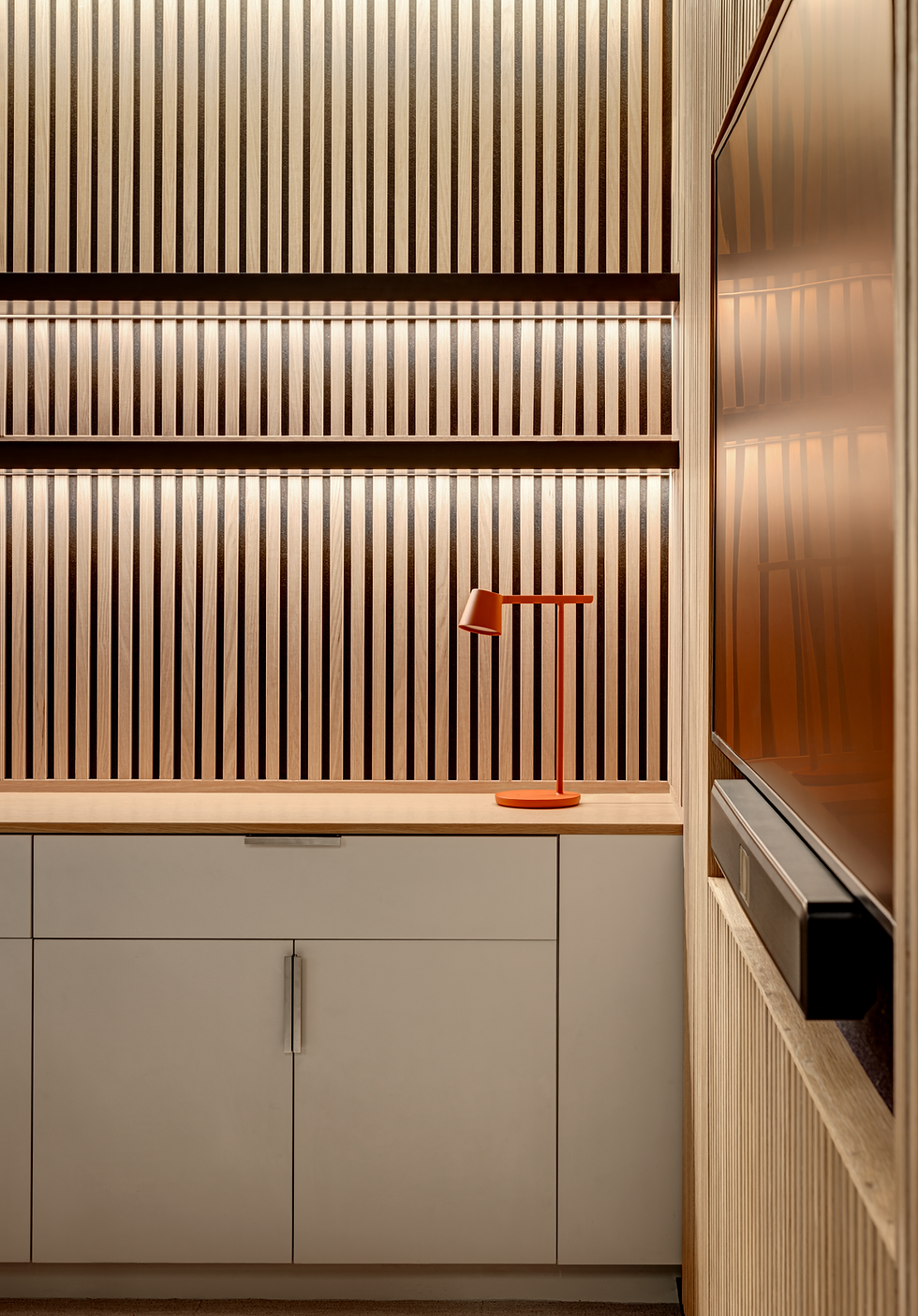 Close up of modern acoustical walls with shelves, tv, cool lighting and stylish lamp.