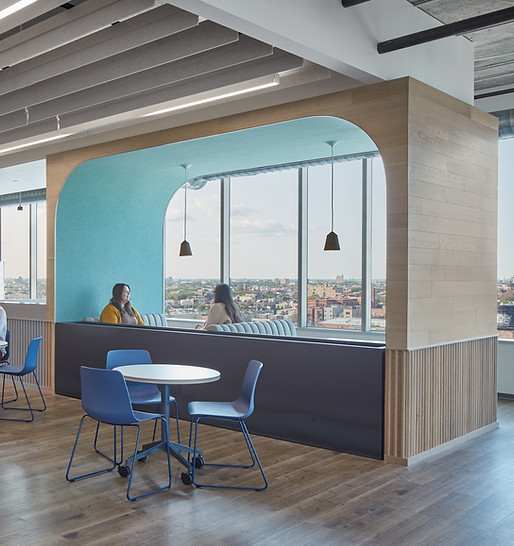 A commercial interior of the company Glassdoor with flutted walls, employees lounging at work and a bright lit interior