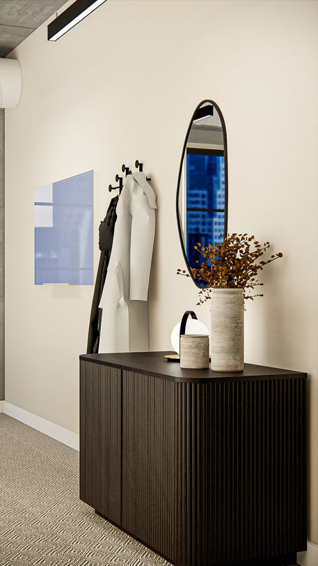 Modern office entry at Webster Capital in Chicago featuring a dark wood fluted console, oval wall mirror, sculptural ceramic vases, integrated lighting, and minimalist coat hooks against a neutral wall.