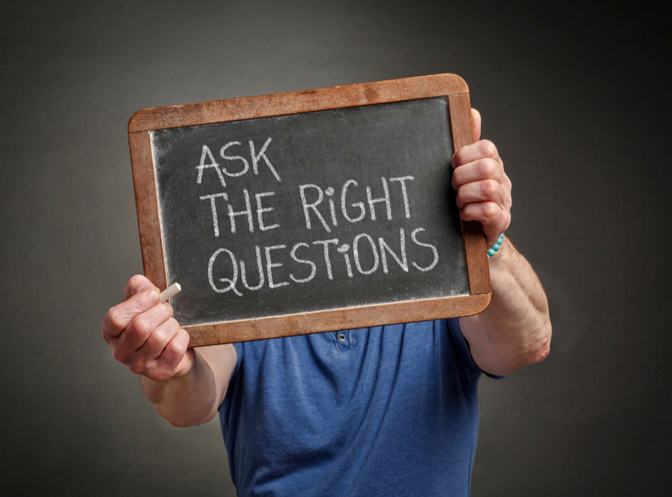 Someone holding up a chalkboard that says 'ask the right questions'