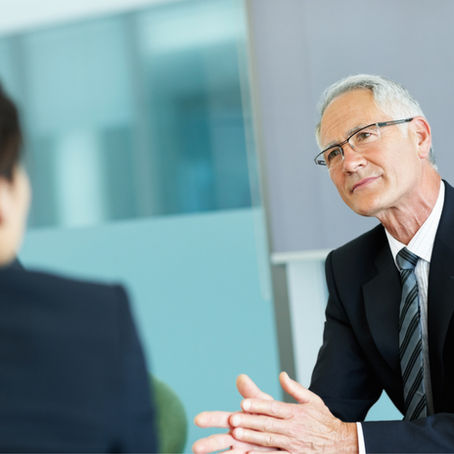 An older man listening to a younger person across the table.