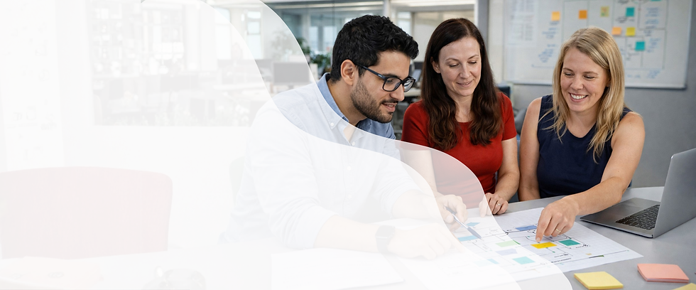 Two women and a man working together at a desk. Looking at a visual storyboard of an elearn